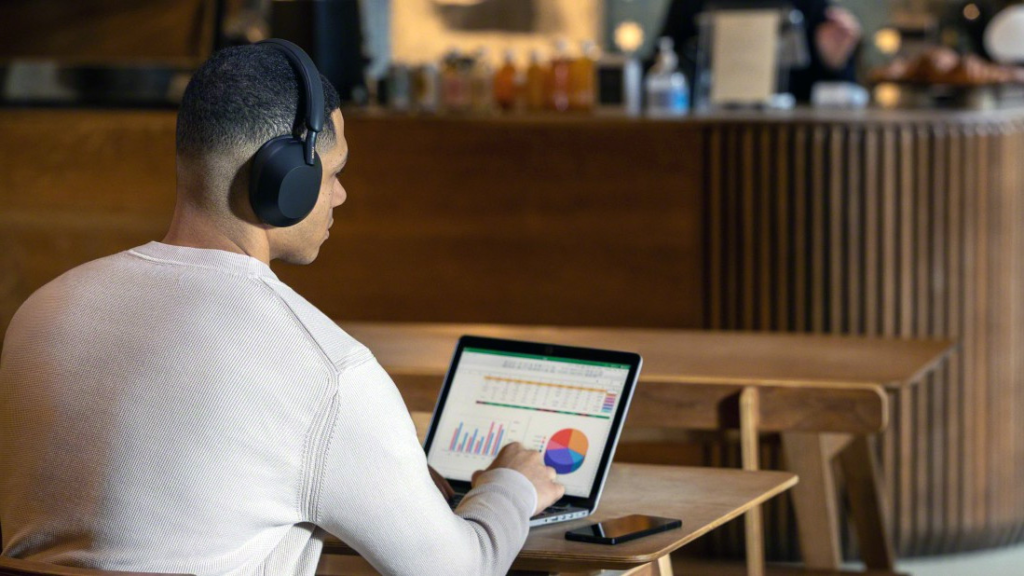 A person using Bluetooth headphones to connect to multiple devices