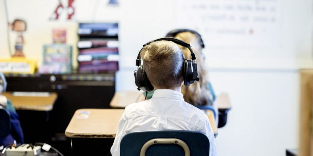A group of students wearing school headphones in a classroom